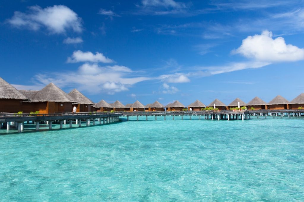 The water villas surrounded by blue sky and sea.